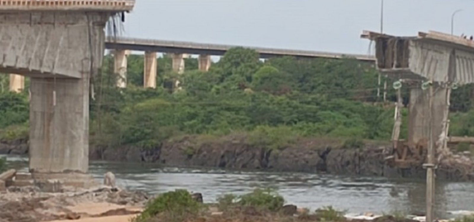 Desabamento de ponte faz caminhões com ácido caírem em rio; buscas serão retomadas na terça