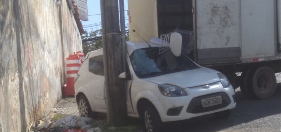 Motorista de caminhão erra manobra e imprensa veículo que estava estacionado