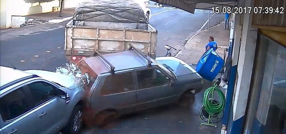 Carreta desgovernada desce rua de ré, arrasta carro e invade loja; veja vídeo