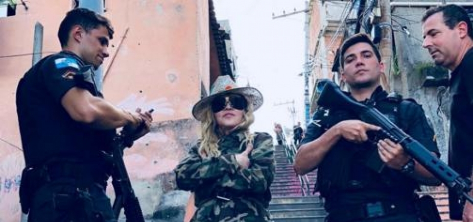 No Rio de Janeiro, Madonna posa ao lado de PMs em favela e é criticada